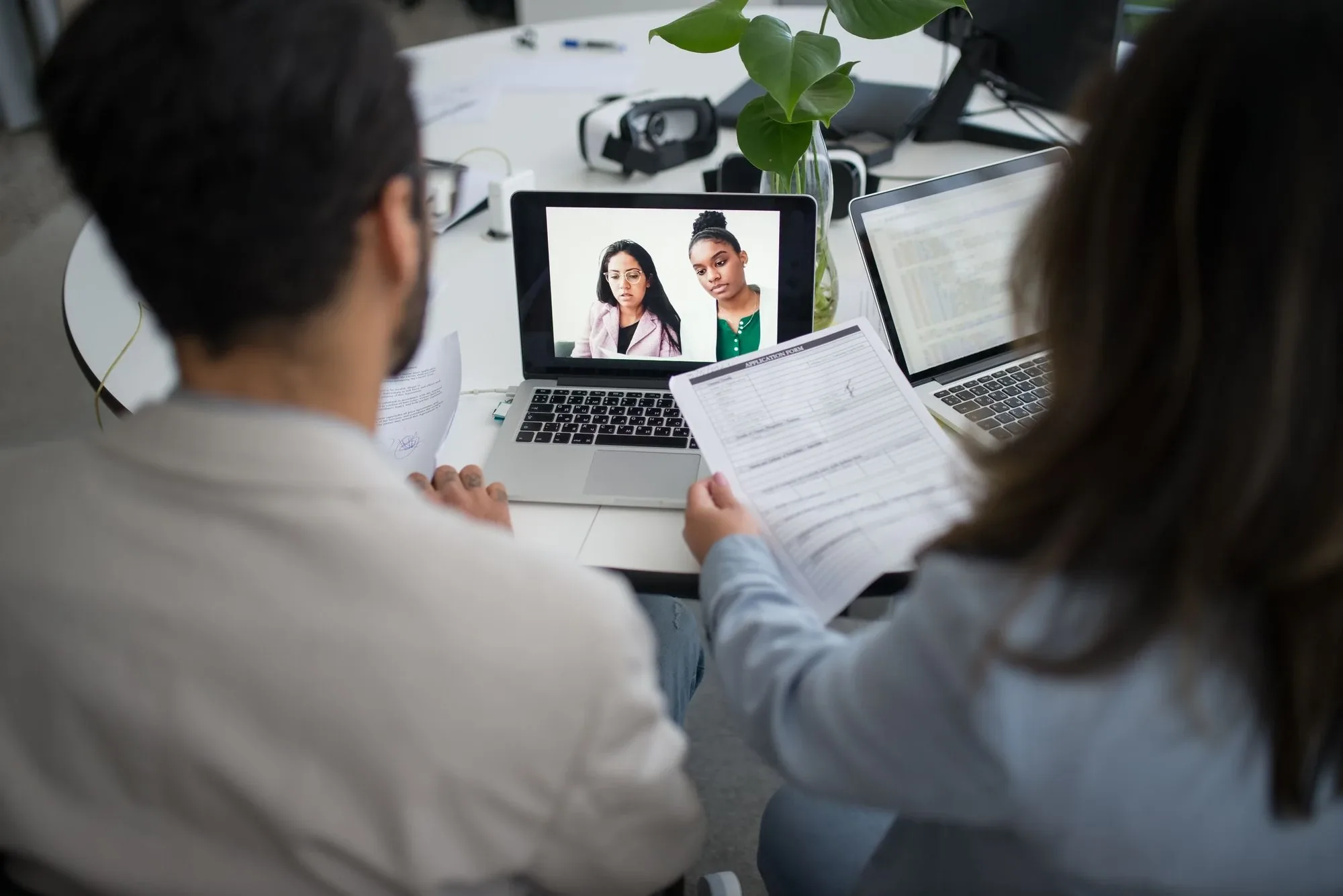Professionals interviewing a candidate on a laptop video call